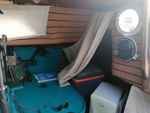 a small room with a table and a window at Dormir sur un bateau in Cap d'Agde