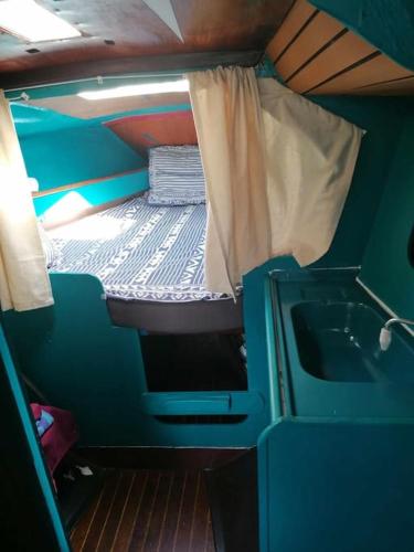 Cette petite chambre comprend un lit et un lavabo. dans l'établissement Dormir sur un bateau, au Cap d'Agde