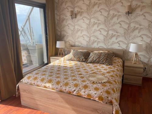 ブローニュ・シュル・メールにあるQueen Marina Face Merのベッドルーム1室(ランプ2つ、窓付)