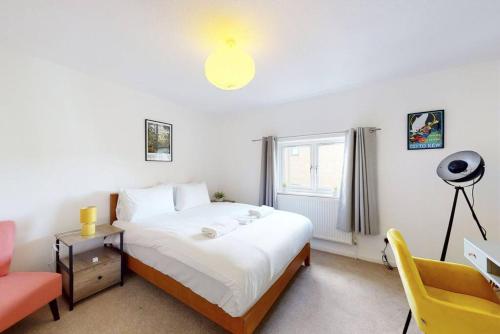 sypialnia z łóżkiem i żółtym krzesłem w obiekcie Modernistic 4 BR house with a garden in Islington w Londynie