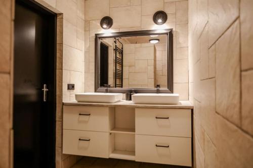 a bathroom with two sinks and a mirror at Appartement ‘t-Yesenaertje in Yerseke