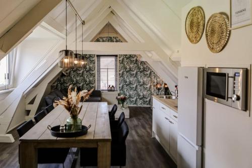 a kitchen and dining room with a table and a couch at Appartement ‘t-Yesenaertje in Yerseke