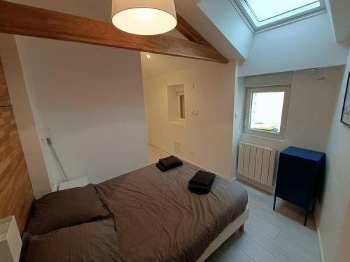 een slaapkamer met een bed in een kamer met een raam bij Douceurs Angevine in Angers