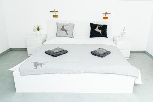 - un lit blanc avec 2 oreillers dans l'établissement City Center Apartment Kitzbühel, à Kitzbühel