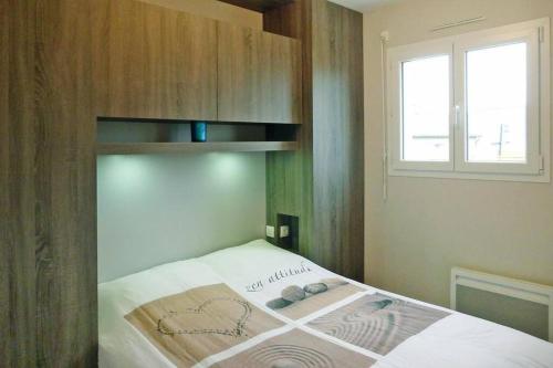 a bedroom with a bed with a shelf and a window at Baie du Mont Saint Michel / Gîte de la Vaquerie 23 in Vains