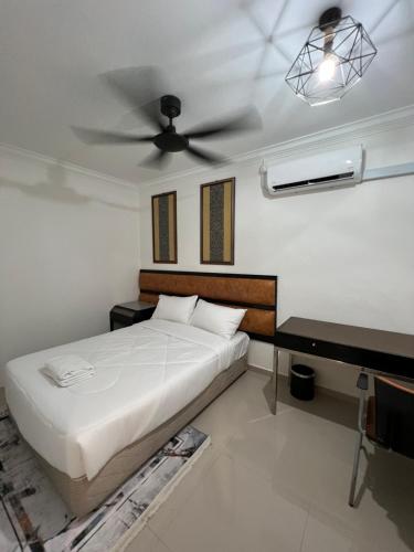 a bedroom with a bed and a ceiling fan at Laena Homestay in Kangar