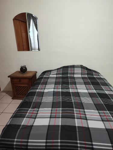 een bed met een zwart en rood geruite deken bij Departamento independiente en Durango México 