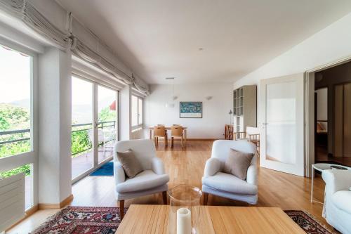 sala de estar con 2 sillas y mesa en Aldesago City View by Quokka 360 - flat with a breathtaking view, en Viganello