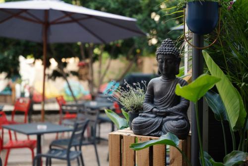 eine Statue eines Buddha auf einem Tisch in der Unterkunft Pfefferbett Hostel in Berlin