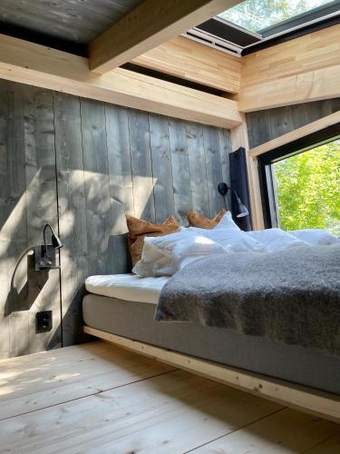 a bedroom with a bed in a wooden wall at Fuglekassehytta in Sparbu