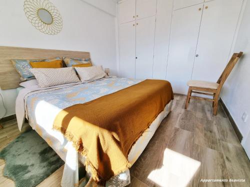 a bedroom with a large bed and a chair at Sublime sea view apartement in Calafell