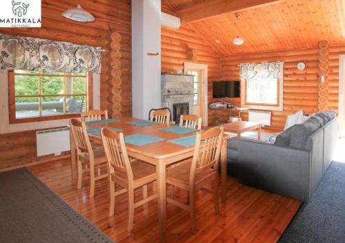 a kitchen and dining room with a table and chairs at Matikkala Cottages in Ruokolahti