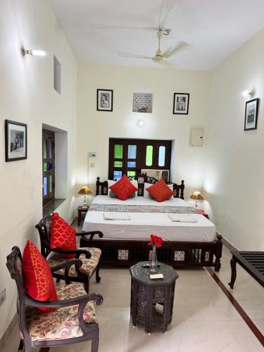a bedroom with a large bed with red pillows at Rawla Mrignayani Palace in Jaipur
