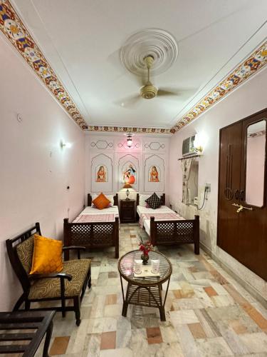 a living room with two beds and a table at Rawla Mrignayani Palace in Jaipur