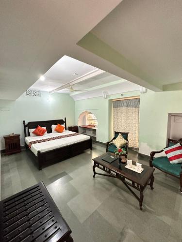 a bedroom with a bed and a couch and a table at Rawla Mrignayani Palace in Jaipur