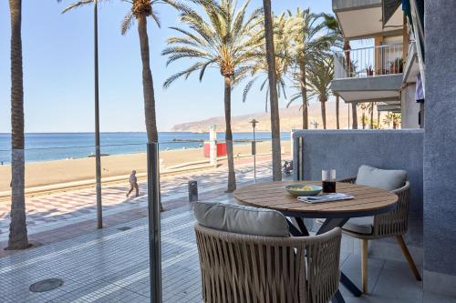 a table and chairs with a view of the beach at Apartaments Paseo Marítimo by Expoholidays in Almería