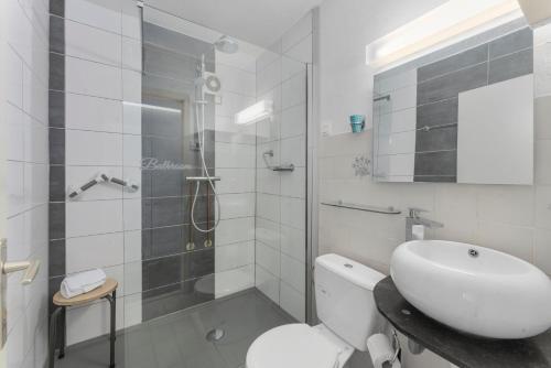 een badkamer met een douche, een toilet en een wastafel bij DilemmaSea - App met zeezicht, terras én zwembad in Middelkerke