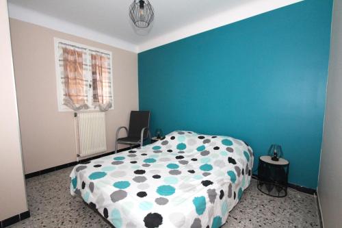 une chambre avec un lit avec un mur bleu dans l'établissement appartement 2 pieces avec parking et vue sur la marina, à Canet