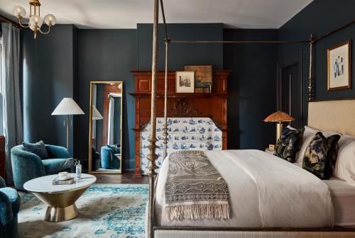 a bedroom with blue walls and a bed and a table at Guild House Hotel in Philadelphia
