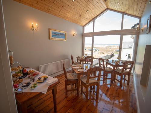 a dining room with tables and chairs with food on them at Ceol na Mara Guest House in Enniscrone