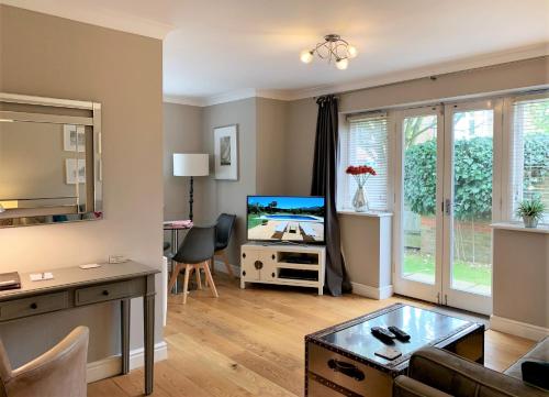 a living room with a couch and a tv at Stylish Two-Bedroom Apartments in Windsor in Windsor