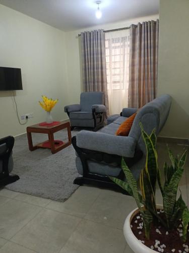 sala de estar con sofá y 2 sillas en Cavendish Square - Hazz_Homes, en Syokimau