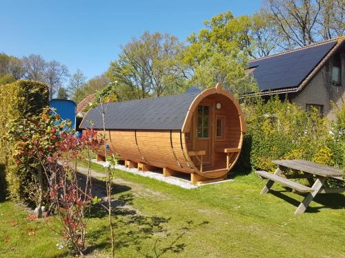 een ronde houten hut in een tuin met een picknicktafel bij Barrel in Oostvoorne in Oostvoorne