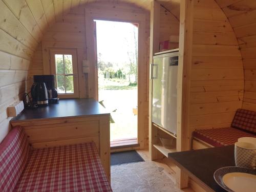 a kitchen in a log cabin with a counter and a stove at Barrel in Oostvoorne in Oostvoorne