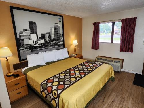 a hotel room with a large bed and a window at WestSpring Inn - Westlake Cleveland in Westlake