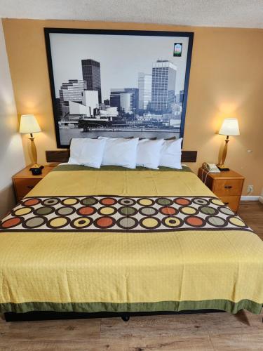 a bed in a hotel room with a large window at WestSpring Inn - Westlake Cleveland in Westlake