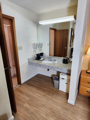 a bathroom with a sink and a counter with a mirror at WestSpring Inn - Westlake Cleveland in Westlake