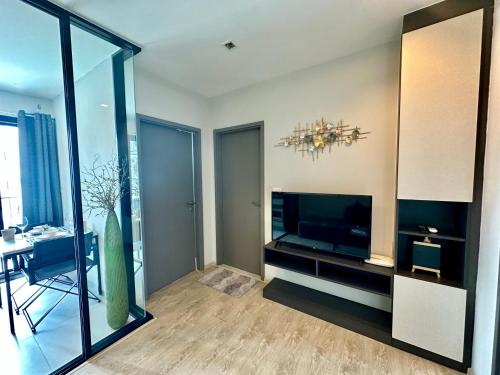a living room with a television and a dining room at Best Location Condo with swimming pool, gym, sauna, washing mashine, Fast internet in Central of Pattaya in Pattaya