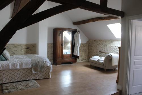 a bedroom with a bed and a mirror and a chair at Petite Ferme Embir 