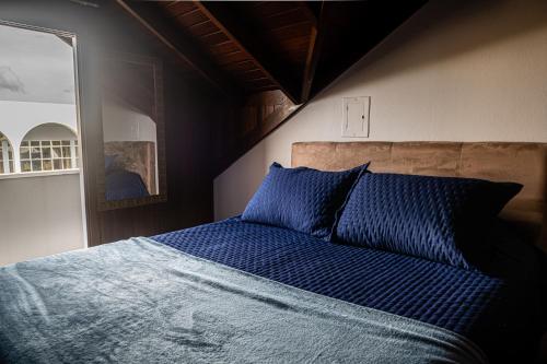 a bedroom with a bed with blue sheets and a mirror at FIKA Residence in Dois Irmãos