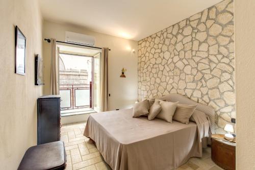 1 dormitorio con 1 cama con pared de piedra en Vico Street 2, en Nápoles