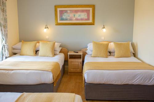 a hotel room with two beds and a table at Ceol na Mara Guest House in Enniscrone