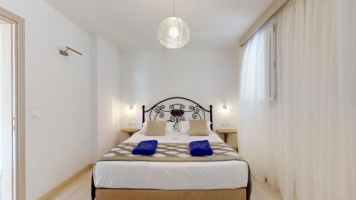 a bedroom with a bed with blue pillows on it at Acrotel Athena Villa in Elia