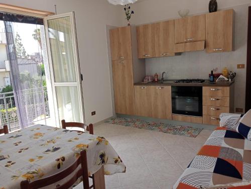 a kitchen with a table and a kitchen with a window at casa LULU due minuti dal mare in Ardore Marina