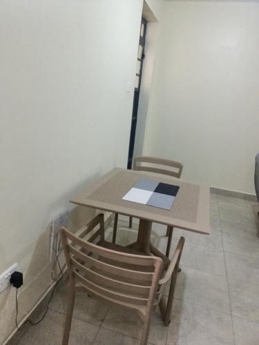 una mesa y sillas en una habitación en Cavendish Square - Hazz_Homes, en Syokimau