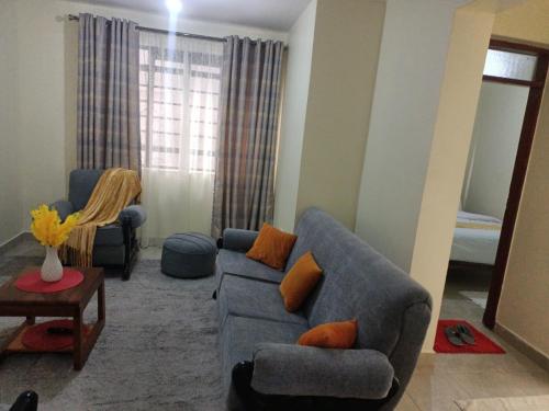 sala de estar con sofá y 2 sillas en Cavendish Square - Hazz_Homes, en Syokimau