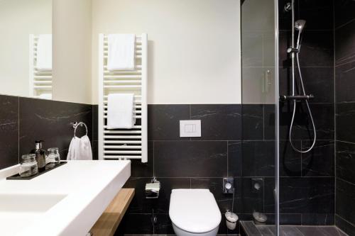 a bathroom with a sink and a toilet and a shower at Vienna House Easy by Wyndham München in Munich
