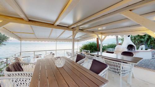 a wooden table and chairs on a patio with the ocean at Acrotel Athena Villa in Elia