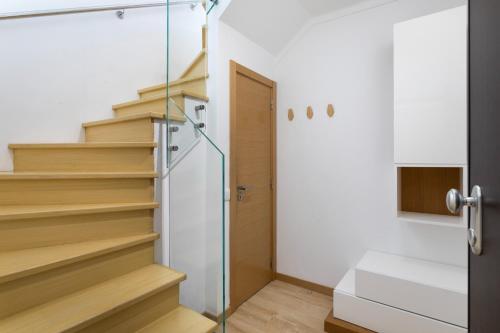 una escalera en una casa con puerta de cristal en Luxury Beachfront 2 Bedroom's Penthouse - Mar do Sol By Centralgarve, en Quarteira