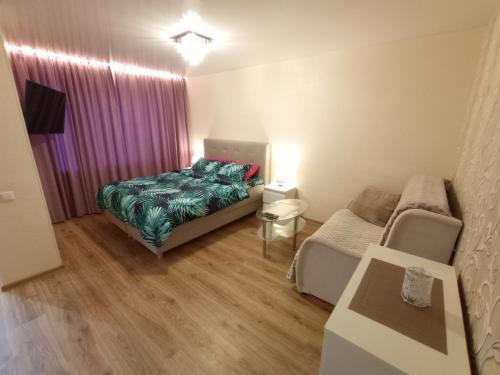 a small bedroom with a bed and a couch at Perfect Studio in Narva center in Narva