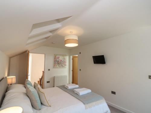 a bedroom with a large white bed and a flat screen tv at Bailey house in Bainton