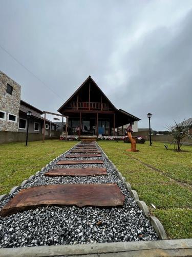 una pasarela frente a una casa con un edificio en Recanto na Serra Bananeiras en Bananeiras