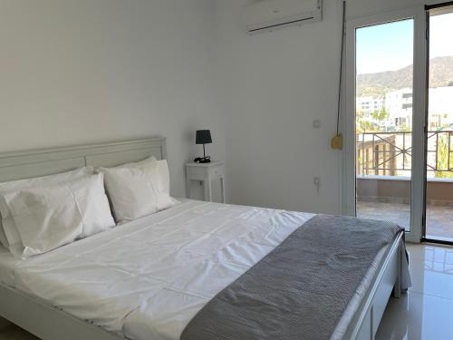a white bed with white sheets and pillows in a bedroom at Locals Apartment Karpathos in Karpathos Town