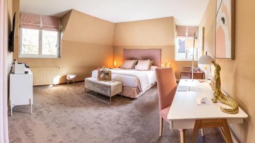 a hotel room with a bed and a table at Le Manoir De La Poterie & Spa in Cricquebœuf