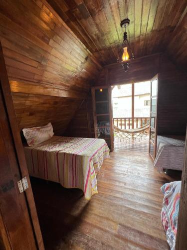 a room with two beds in a wooden cabin at Recanto na Serra Bananeiras in Bananeiras