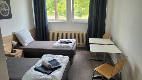 um pequeno quarto com 2 camas e uma janela em ABO Penzion Chomutov em Chomutov